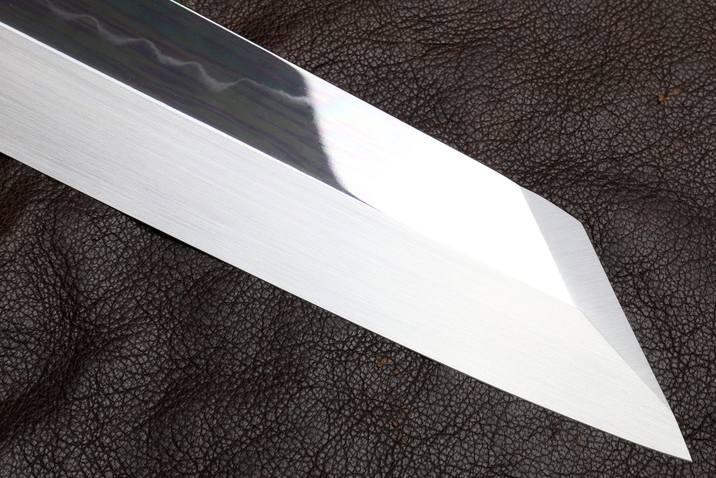 Mirror-polished knife blade close-up with sharp tip.
