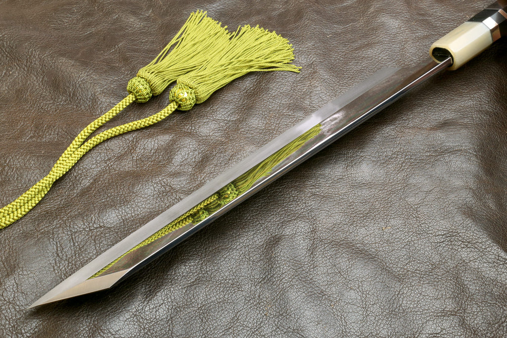Sheathed knife with long mirror blade, green cord tassel, metal end cap.