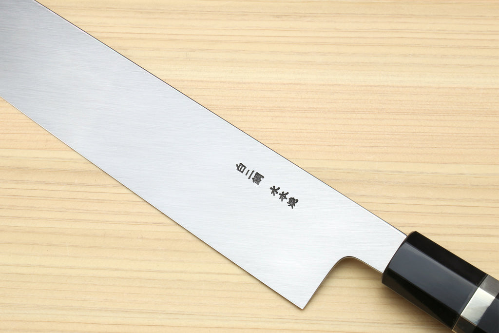 Kiritsuke chef knife close-up: white steel blade with engraving near heel