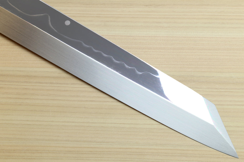 Kiritsuke chef knife tip close-up with wavy pattern on white steel blade