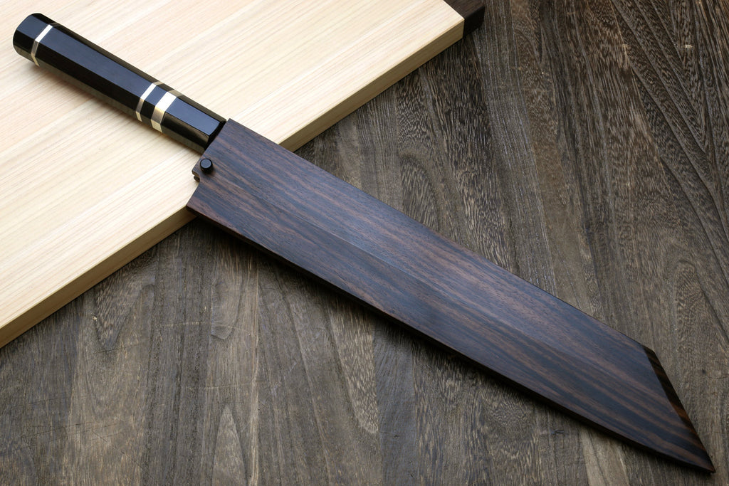 Kiritsuke chef knife side view with dark ebony handle and dark saya sheath
