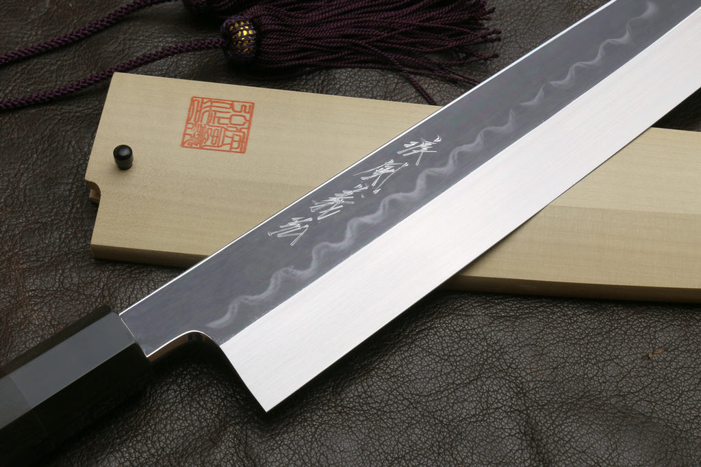 Kiritsuke knife on light saya with wavy blade finish and engraved kanji