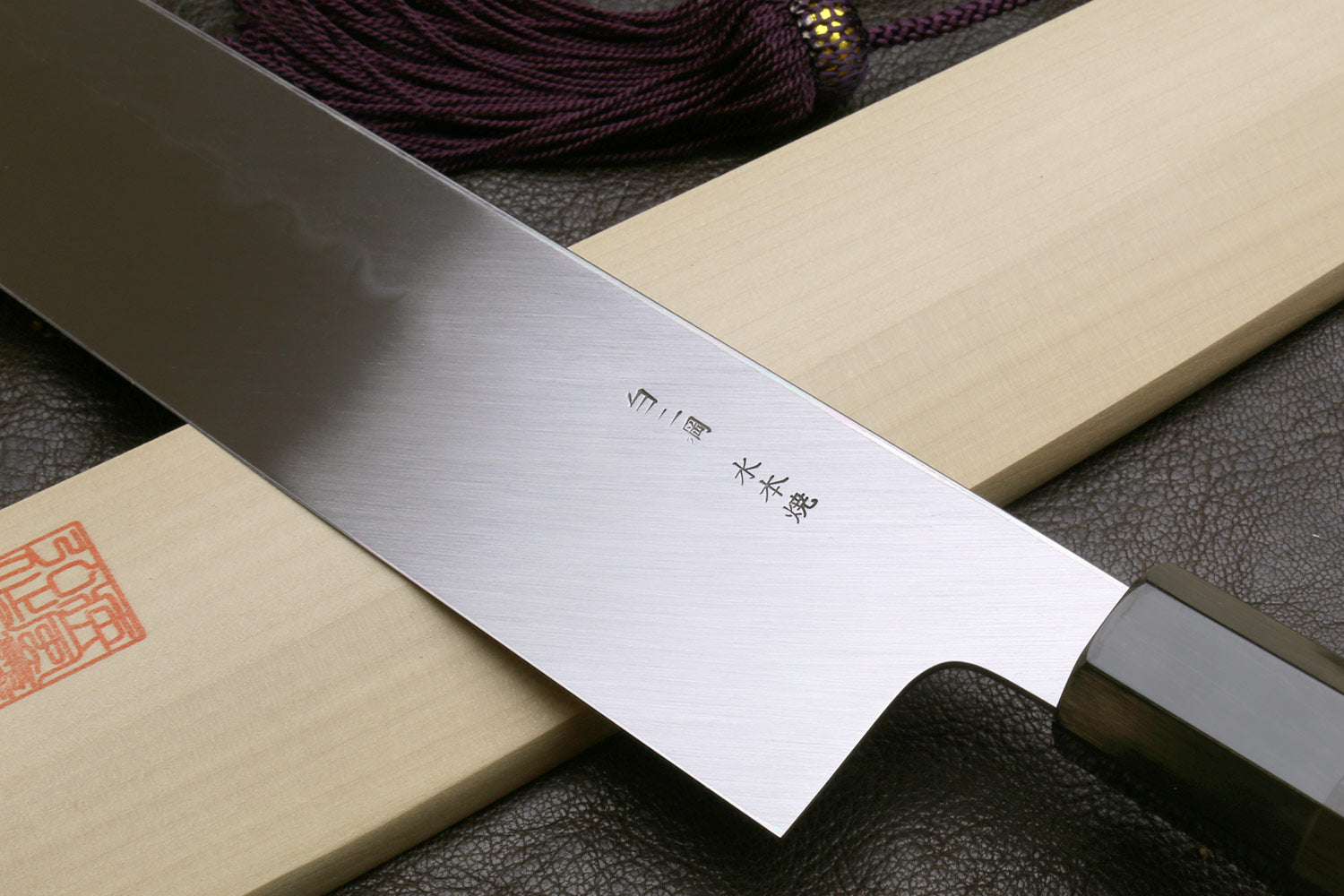 Kiritsuke knife with mirror-polished blade and etched markings near the handle