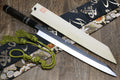 Japanese kiritsuke knife with mirror-finished blade, dark handle, and patterned cloth wrap