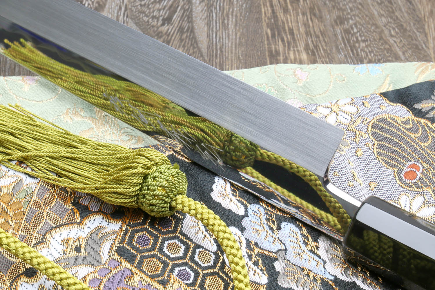 Japanese kitchen knife, mirror-finished blade, black handle, green cord wrap