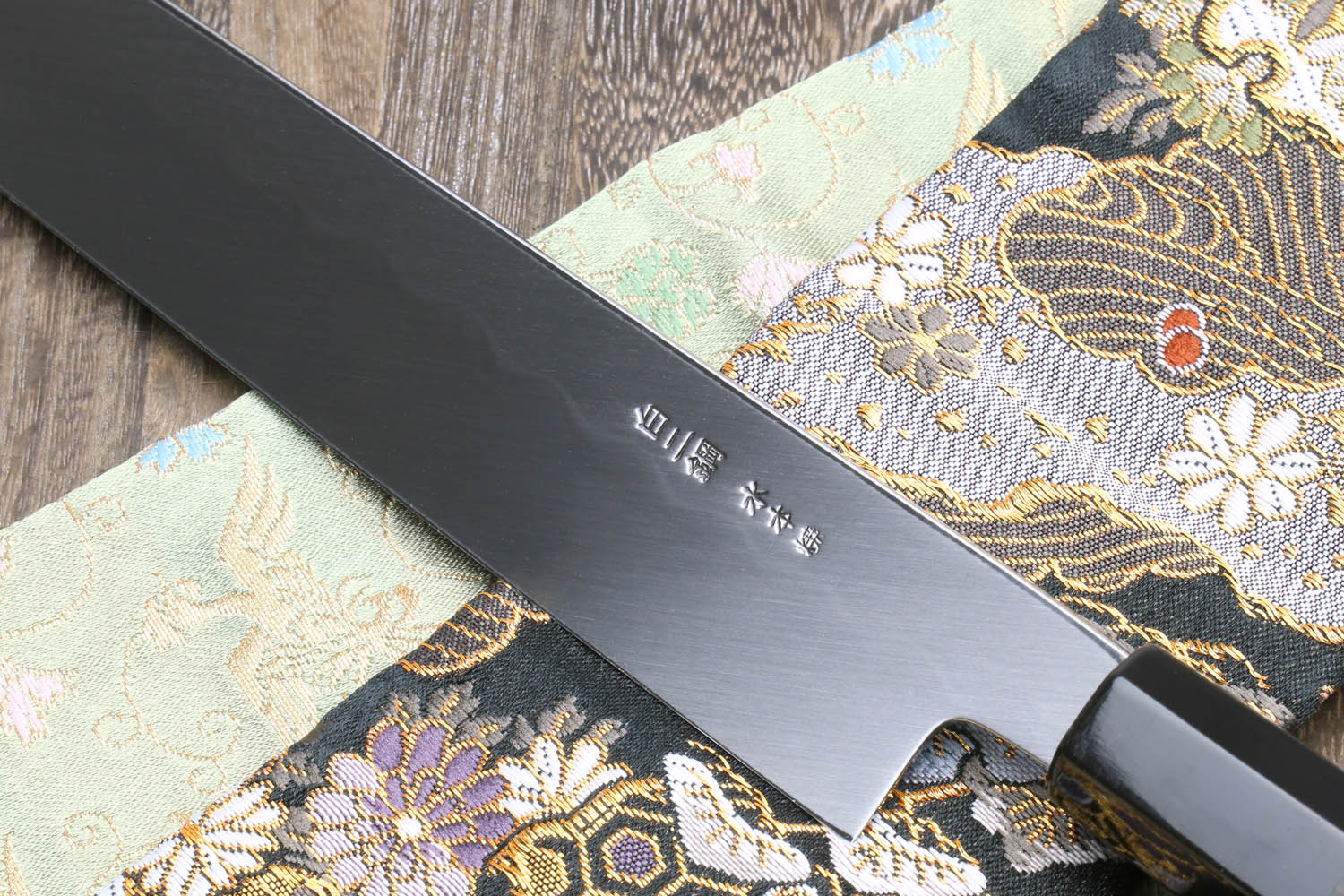 Japanese kitchen knife, dark sheath and mirror-finished blade with stamped kanji mark
