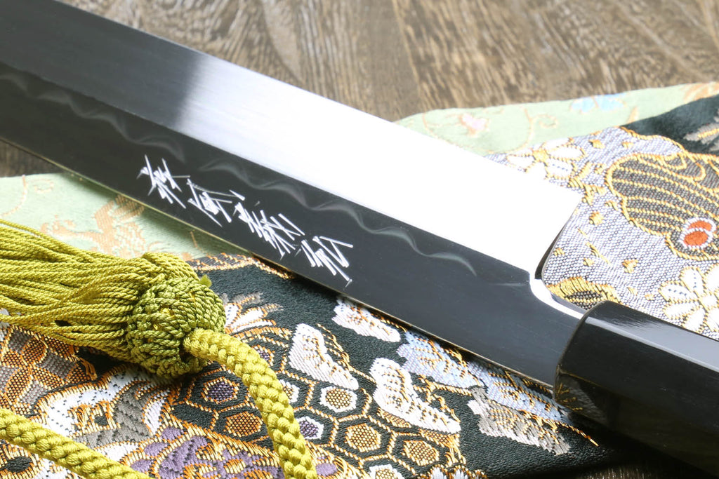 Japanese kitchen knife blade with etched text, black saya and green braided tassels