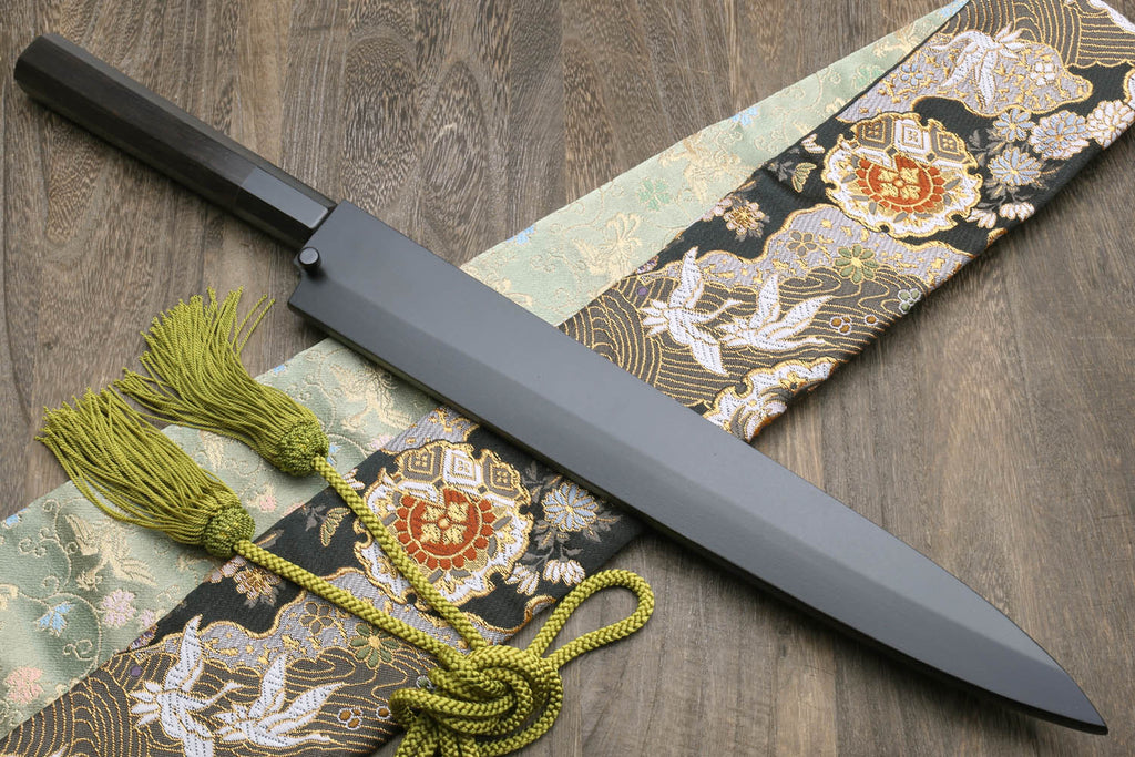 Japanese kitchen knife with black saya, silver blade, ornate cloth wrap and green cord