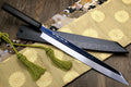 Japanese knife with silver mirrored blade and ebony handle, blue-black spine and tassel cord.