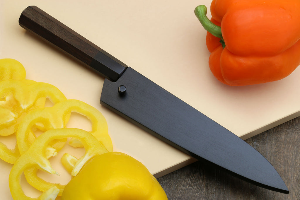 Kurouchi petty knife angled view with dark shitan handle and blue-gray blade