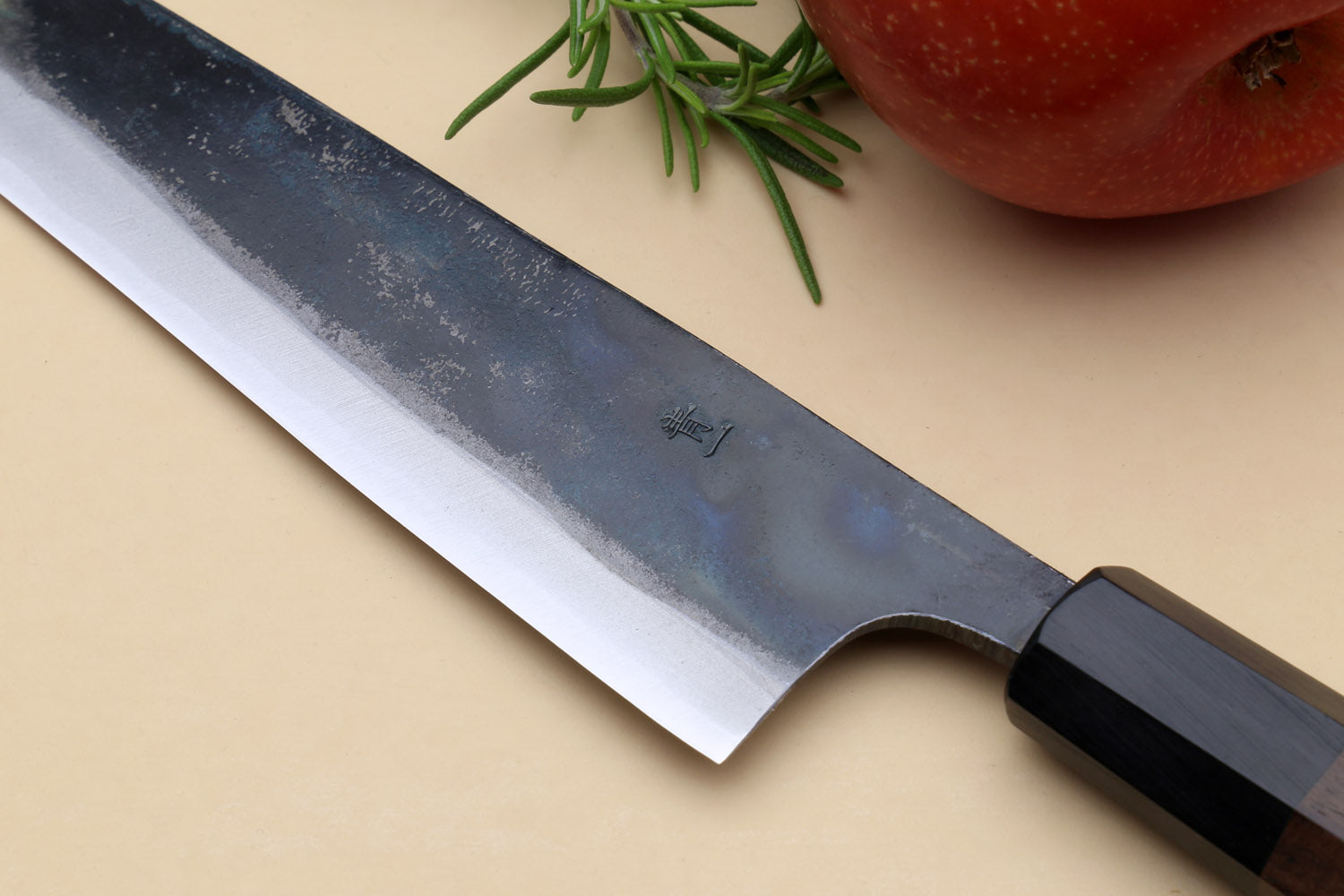 Petty kiritsuke knife detail of kurouchi blade markings near bolster and edge