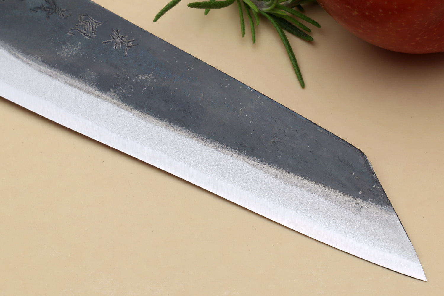 Petty kiritsuke knife close-up of dark kurouchi blade surface and pointed tip