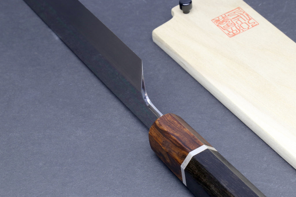 Japanese kiritsuke knife side view with dark steel blade and dark wood handle