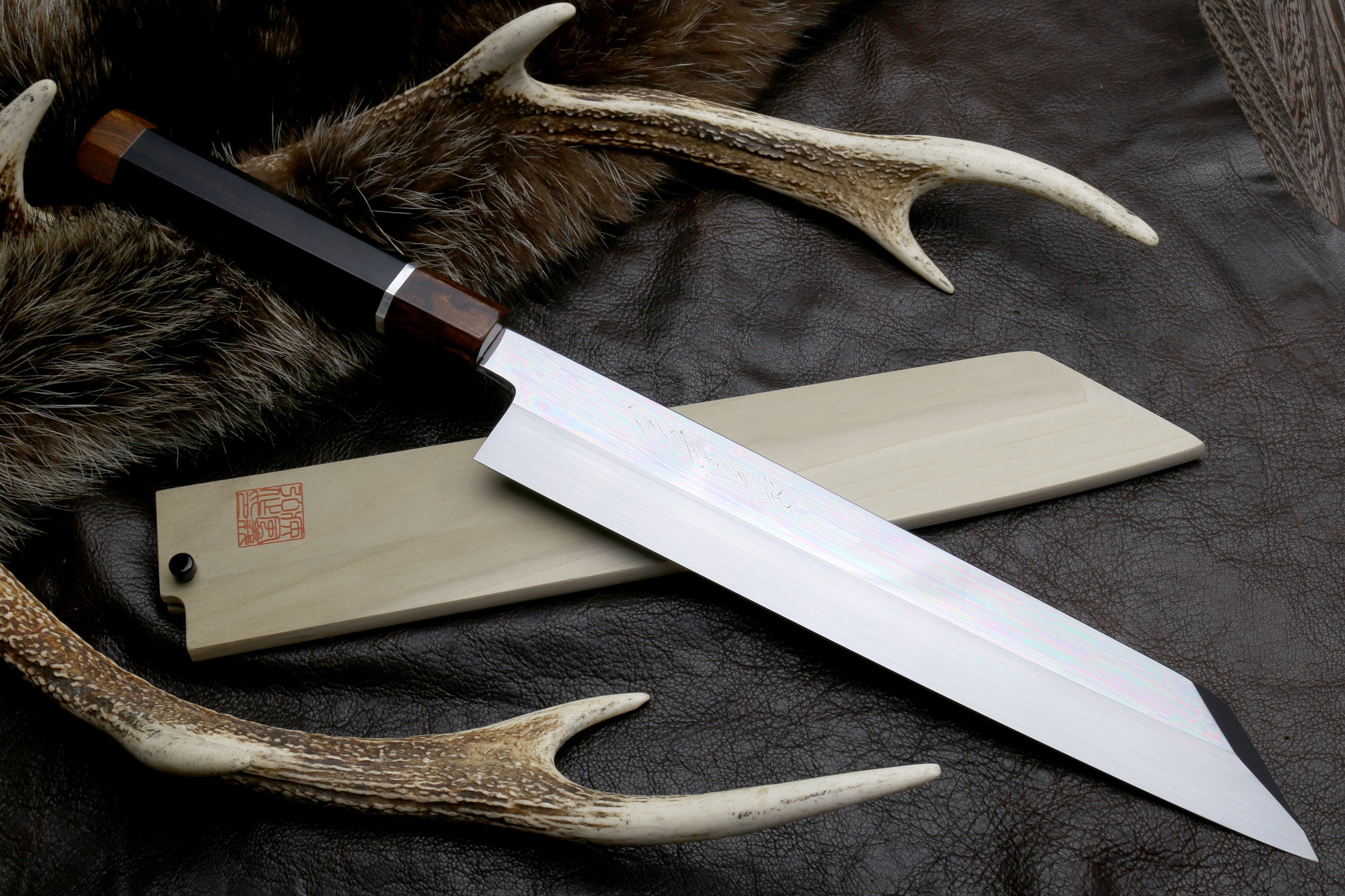 Japanese kiritsuke knife with mirror-finished silver blade and dark wood handle
