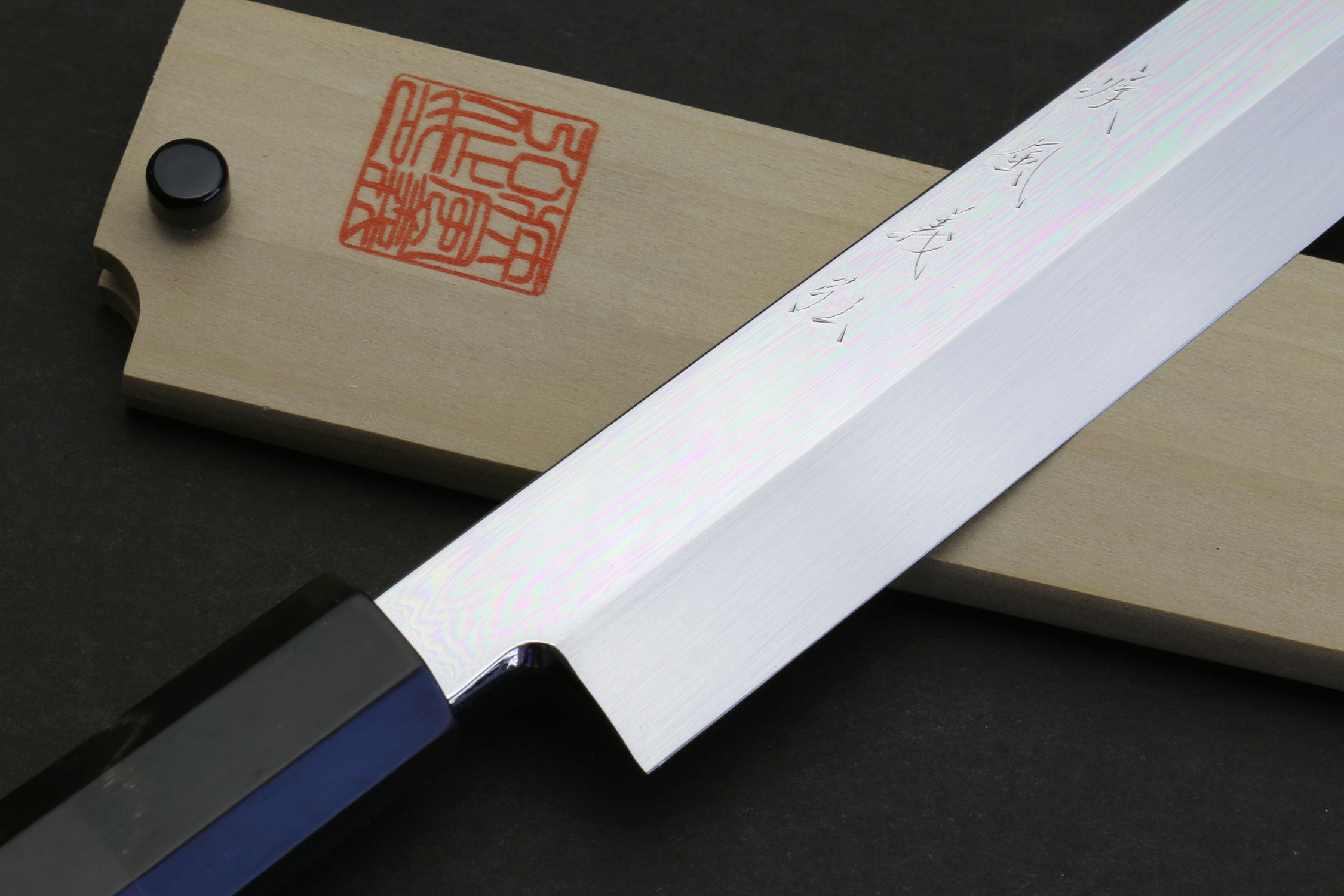 Sakimaru sushi knife with polished blade and dark handle, side angle view