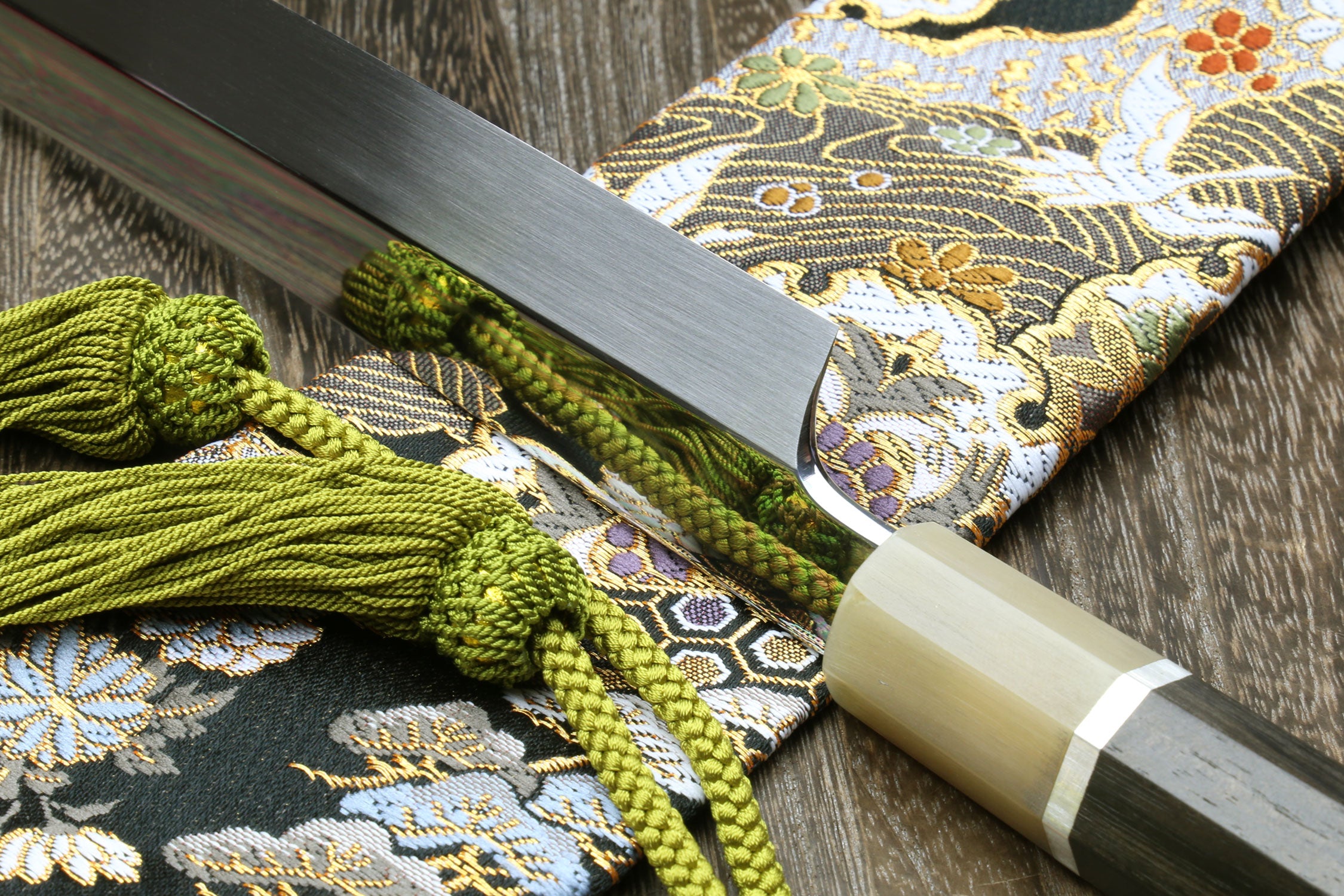 Japanese katana blade close-up in sheath, silver finish, light wood fittings.