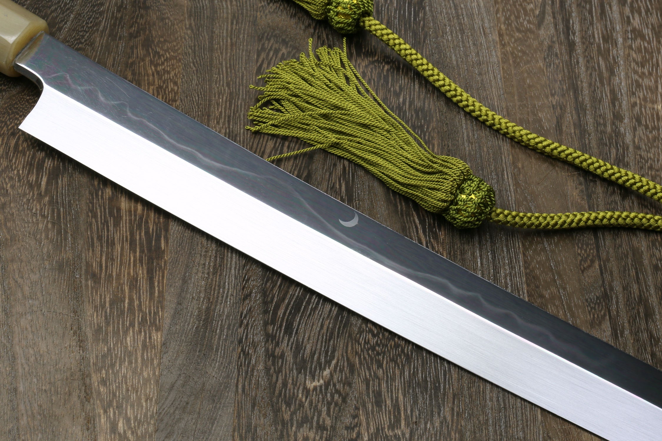 Japanese katana blade side view, silver edge with dark spine.
