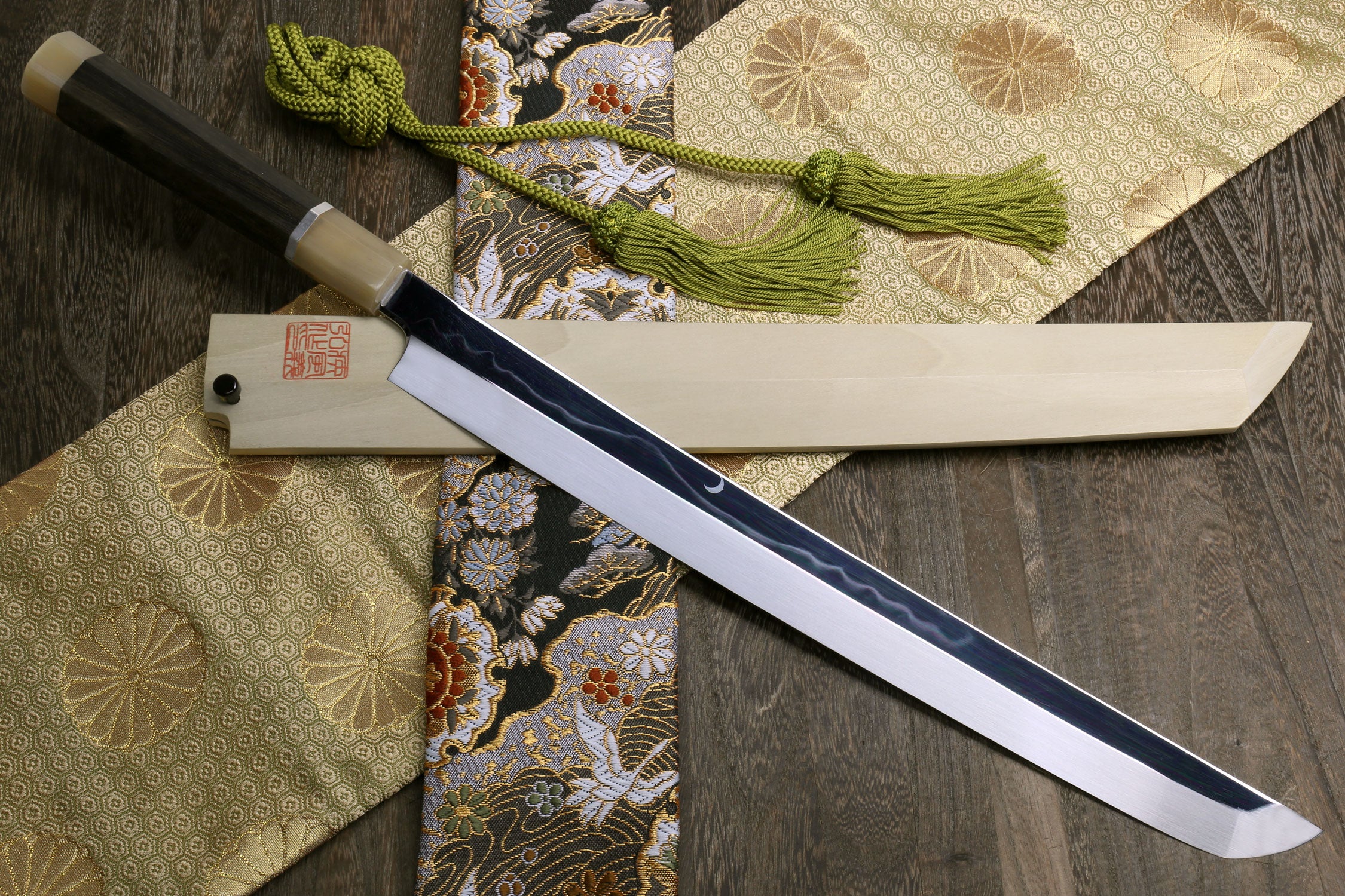 Japanese katana sword, mirror-finished silver blade, ebony handle, green cord wrap.