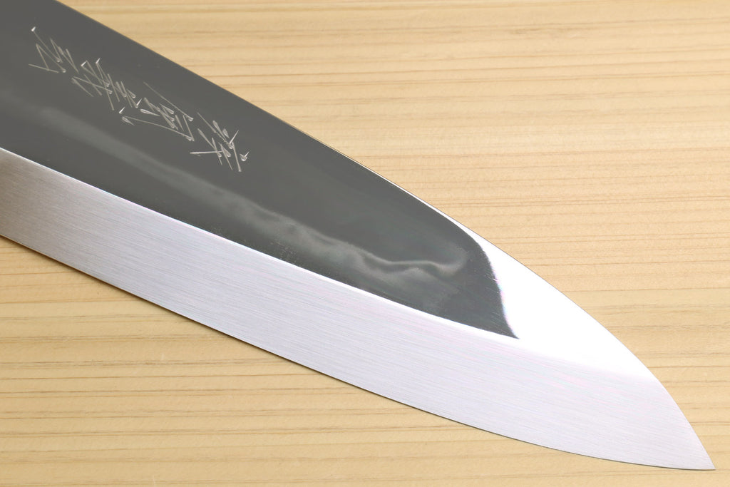 Japanese chef knife with mirror-finished tip and beveled edge, silver blade on light wood