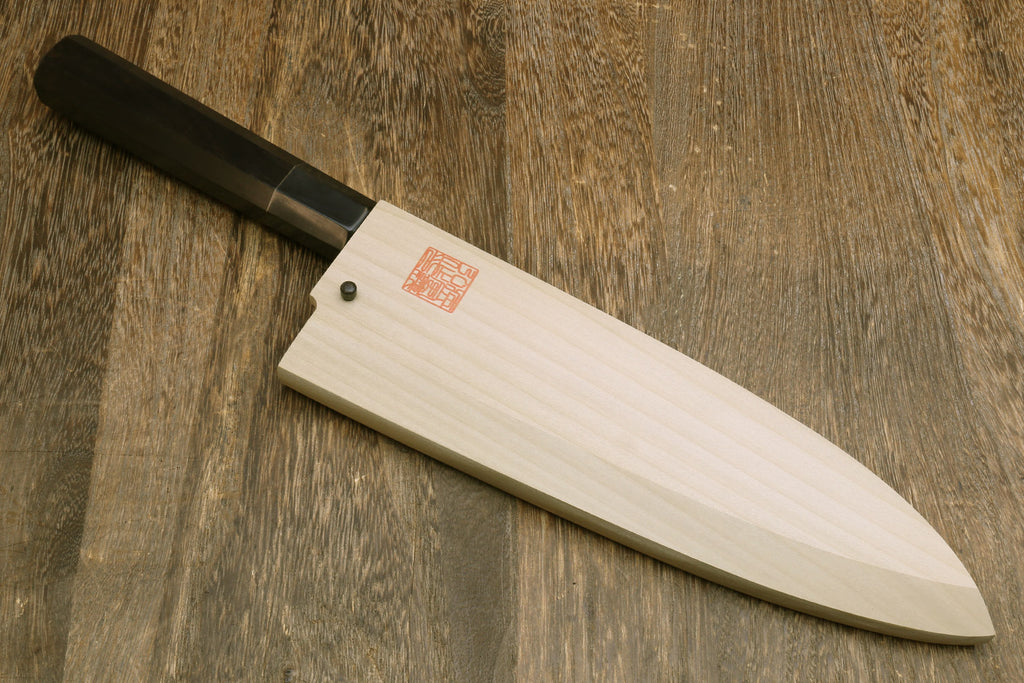 Japanese chef knife with mirror-finished silver blade and black handle, in wooden saya