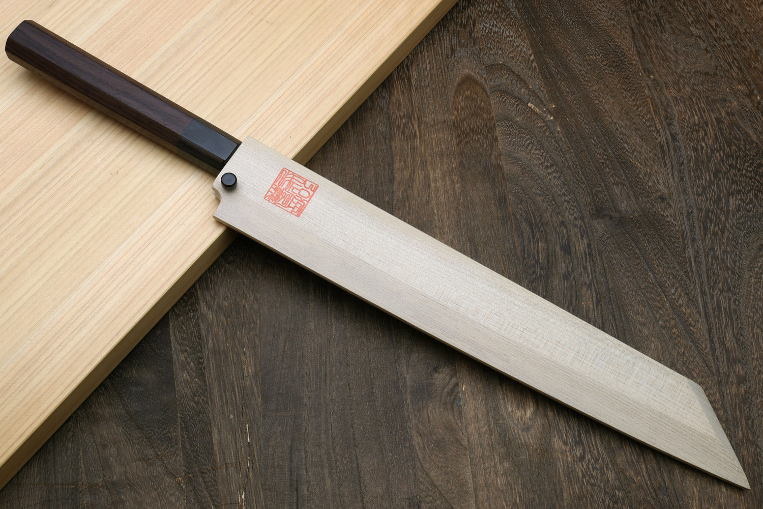 Japanese sushi knife with narrow silver blade and dark rosewood handle