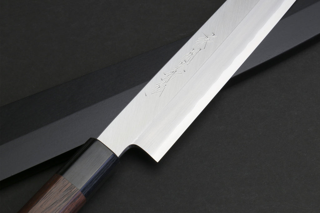 Yanagi knife blade close-up with stainless finish and partial rosewood handle