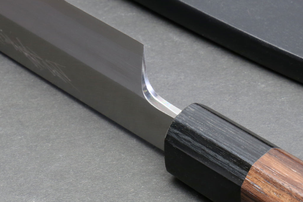 Yanagi knife handle close-up with rosewood scales and dark metal collar