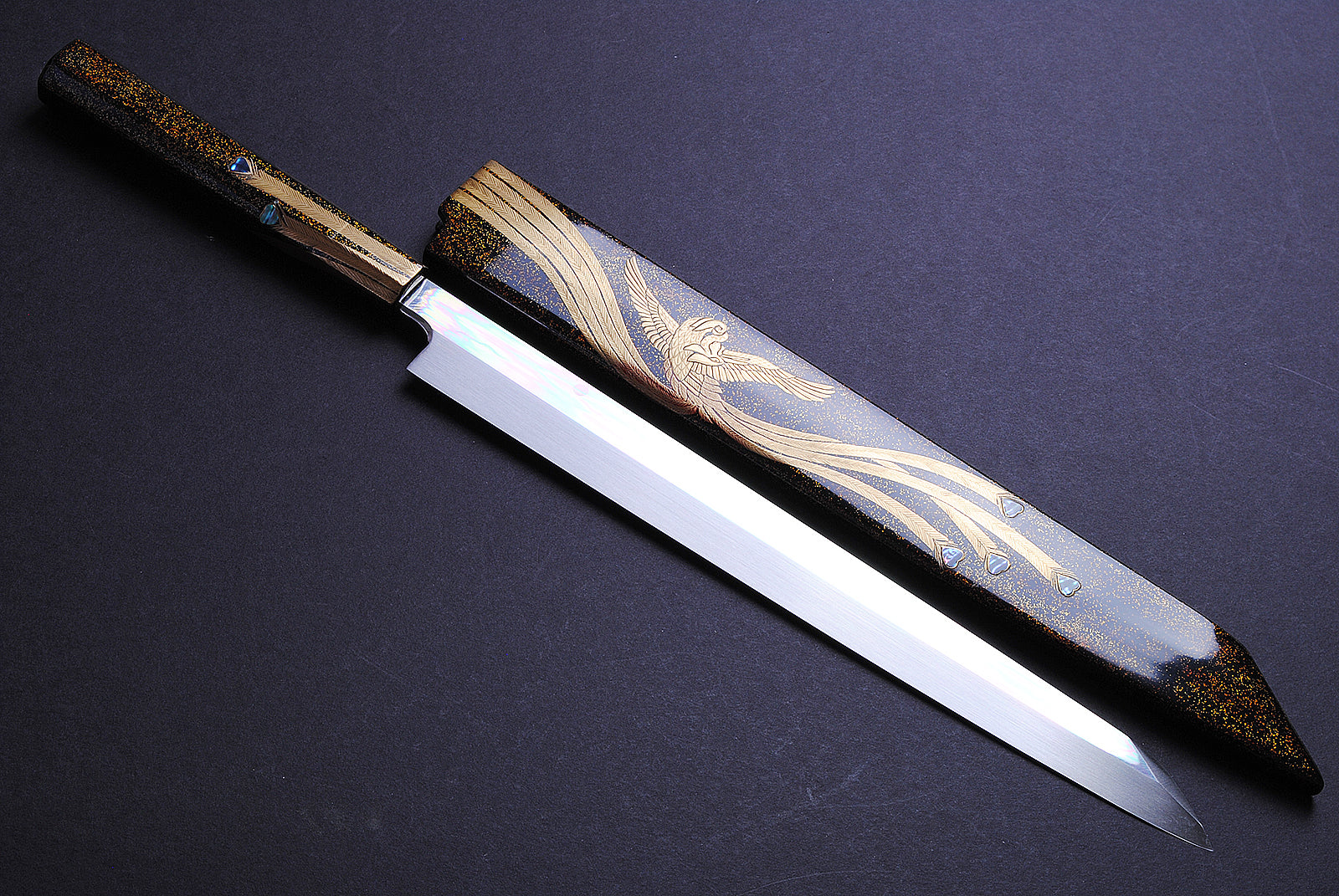 Yanagi kiritsuke knife with ornate gold-and-silver pattern on mirror blade and rosewood handle