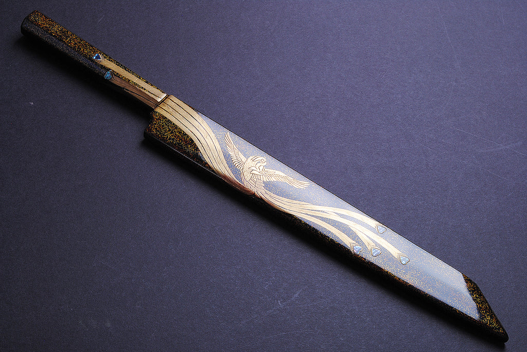Yanagi kiritsuke knife angled view with ornate gold-and-silver pattern on mirror blade