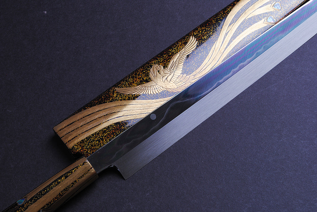 Yanagi kiritsuke knife close-up: gold-and-silver phoenix motif on mirror-finished blade