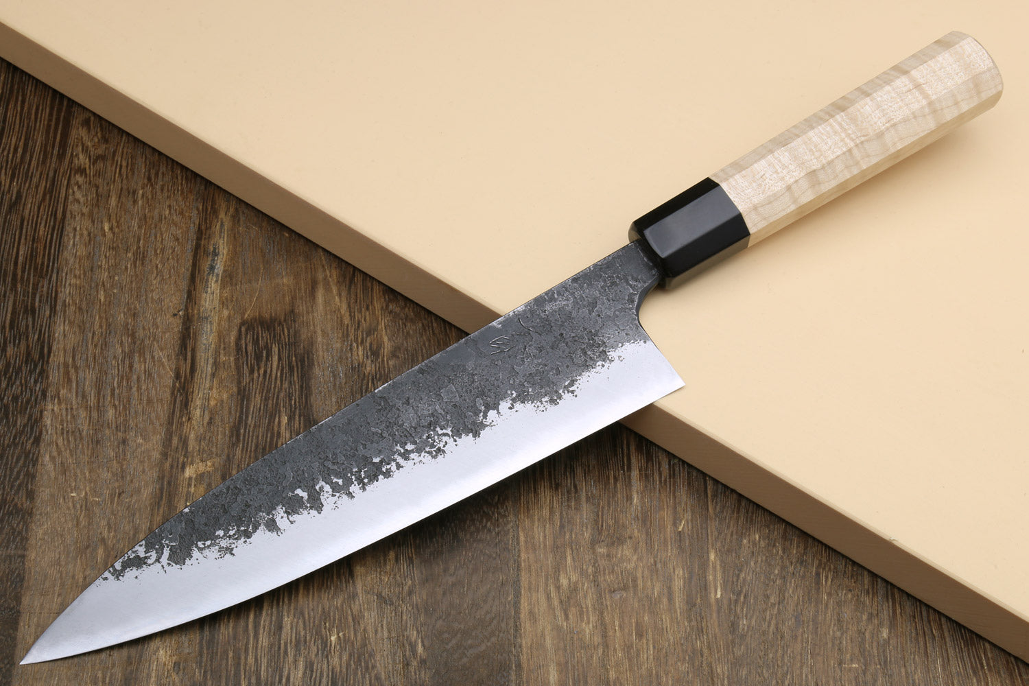 Gyuto chef knife showing white blade edge with nashiji texture and light camphor handle.