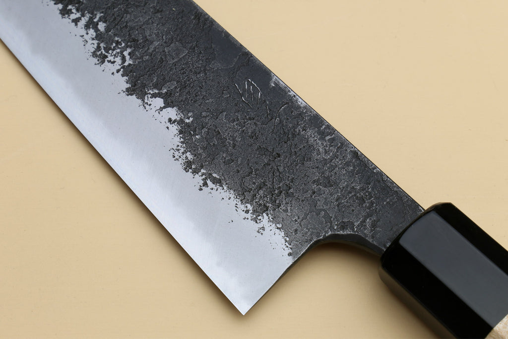 Chef gyuto knife blade with dark bolster and black blade spine; white nashiji steel.