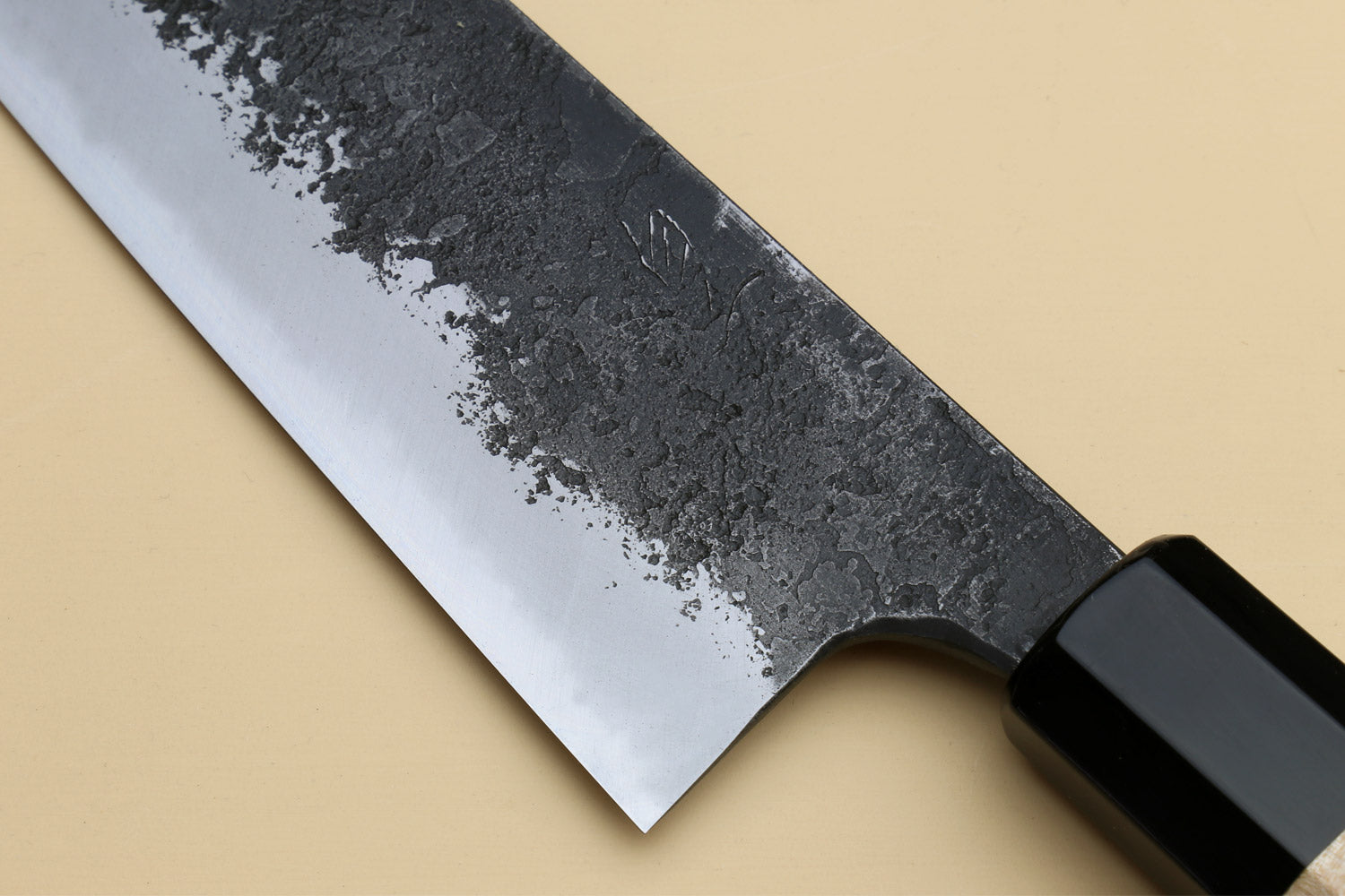 Chef gyuto knife blade with dark bolster and black blade spine; white nashiji steel.