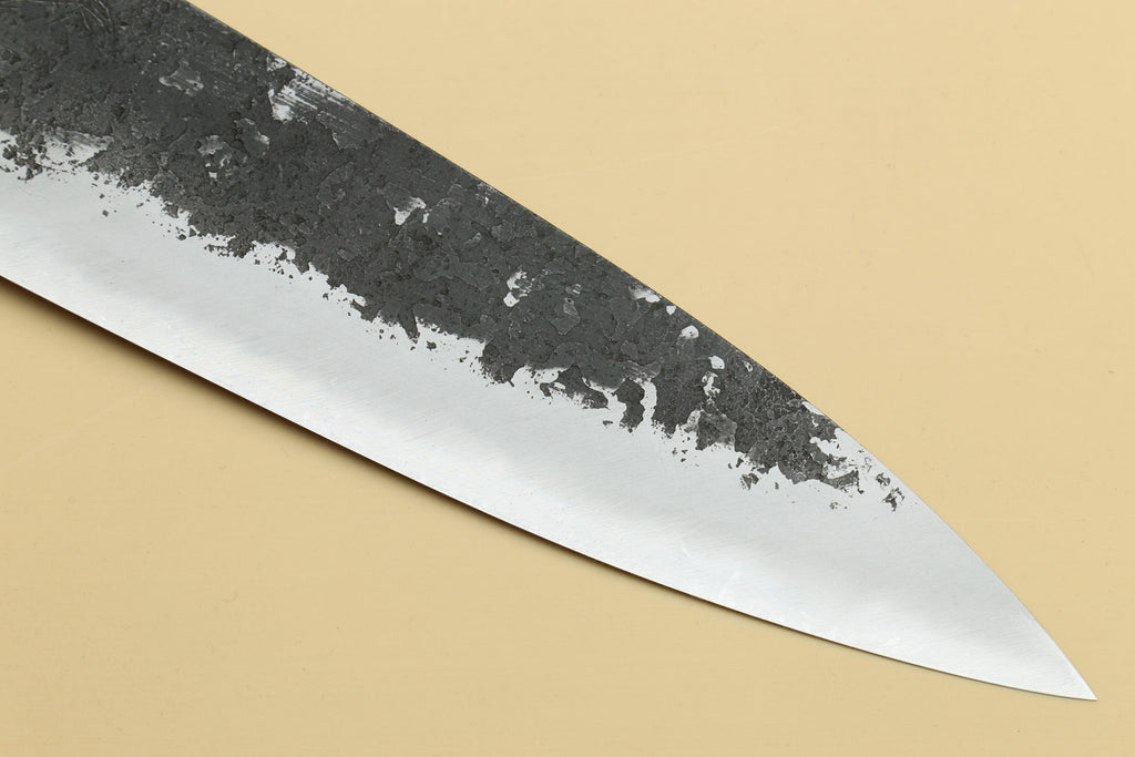 White steel gyuto blade with speckled nashiji pattern and sharp pointed tip.