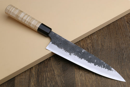 Gyuto chef knife with white nashiji steel blade and light camphor wood handle, dark bolster.