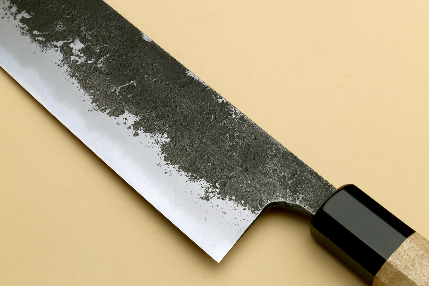 Nakiri knife close-up on curved tip, textured dark blade and wood handle