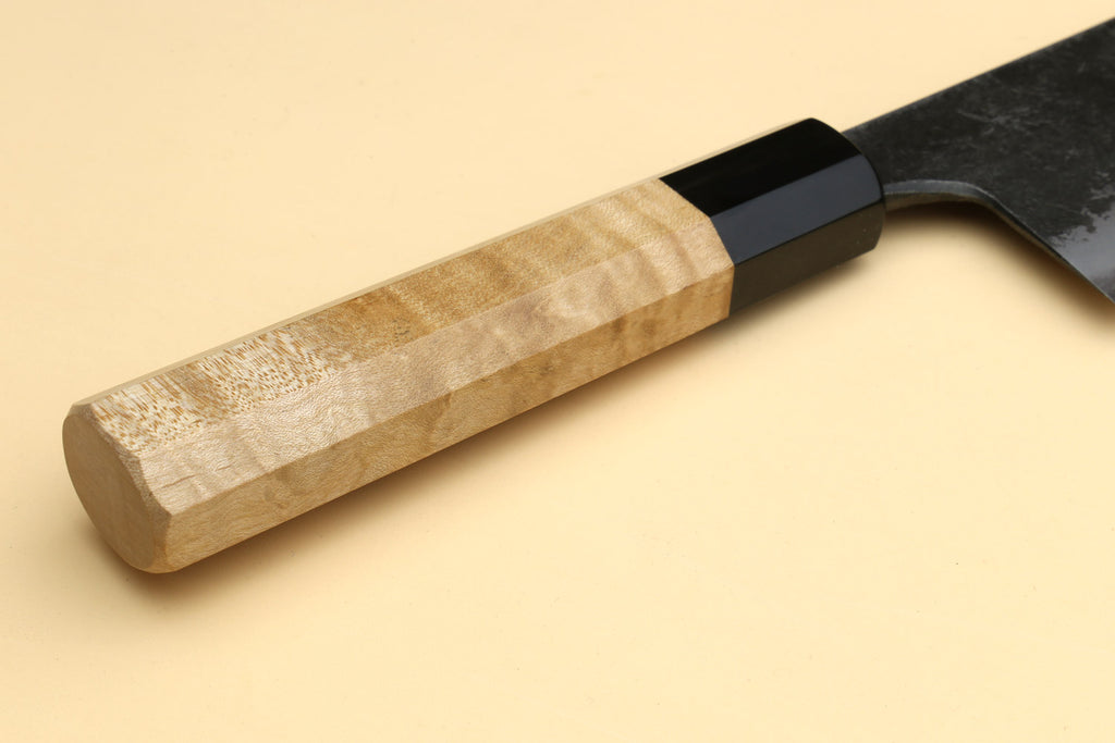 Nakiri knife handle detail, camphor wood grip with black bolster and dark blade