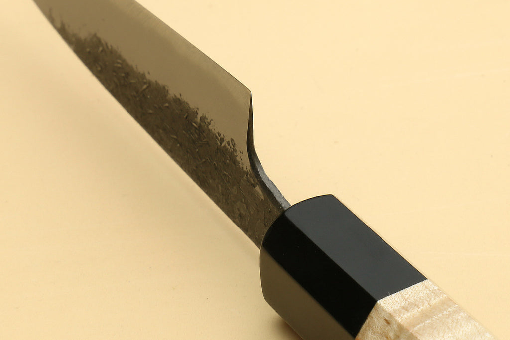 Paring knife blade and black bolster with light camphor wood handle