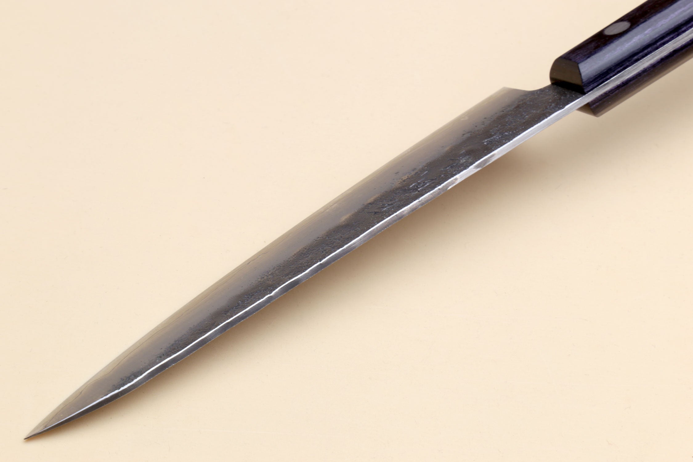 Petty utility knife blade tip with silver steel and dark handle end