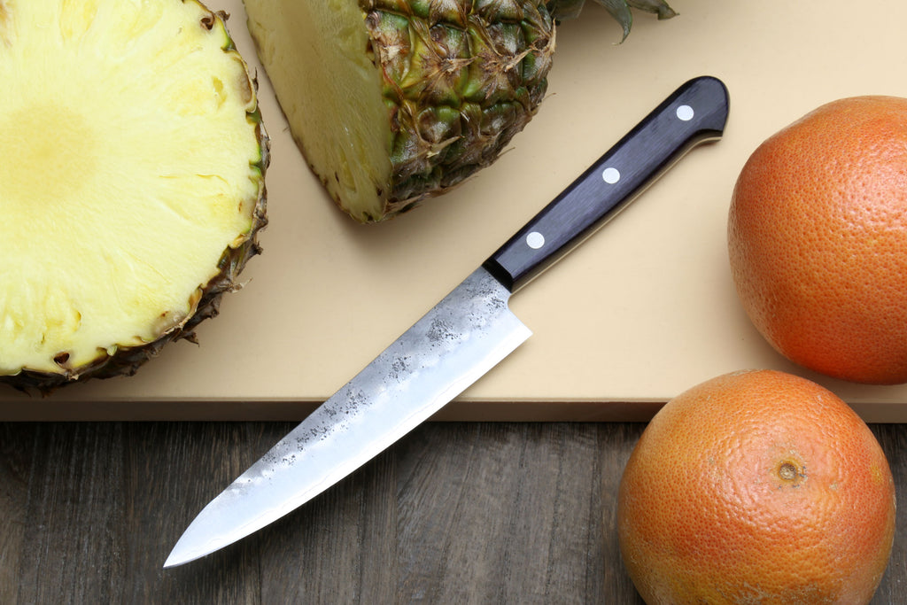 Petty utility knife with dark handle and pointed silver blade