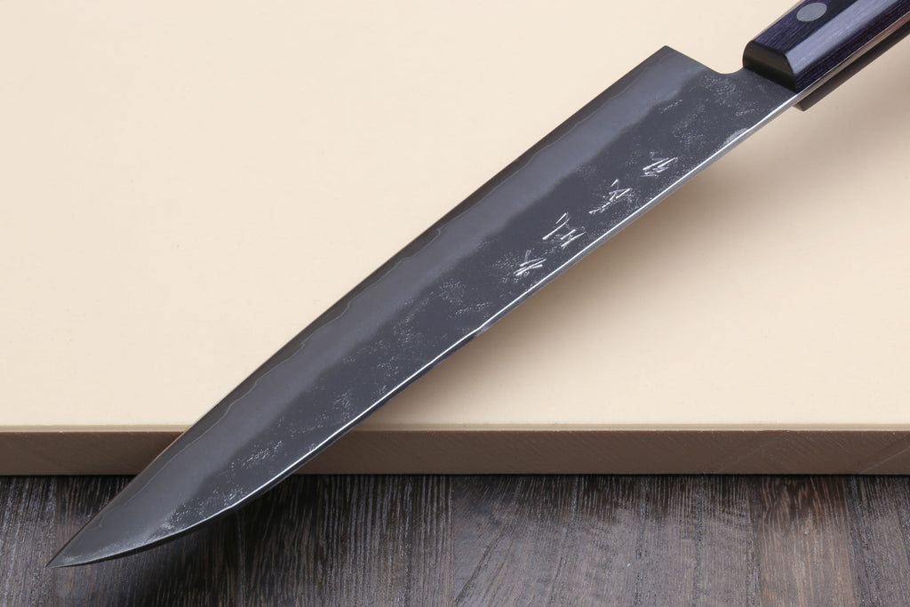 Santoku knife side view, dark blue handle and silver blade with etched markings