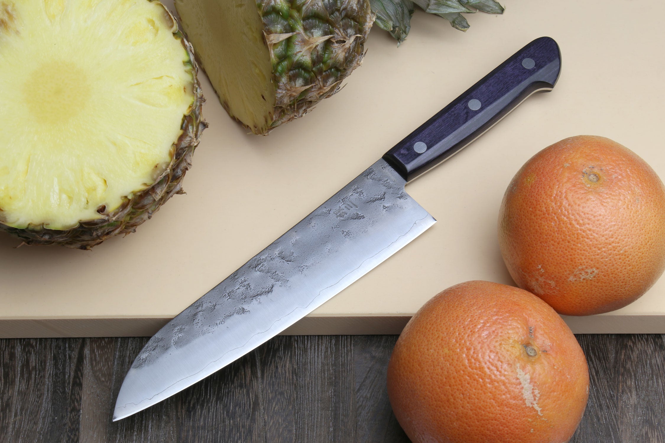 Santoku knife with dark blue handle and silver patterned blade, wide tip