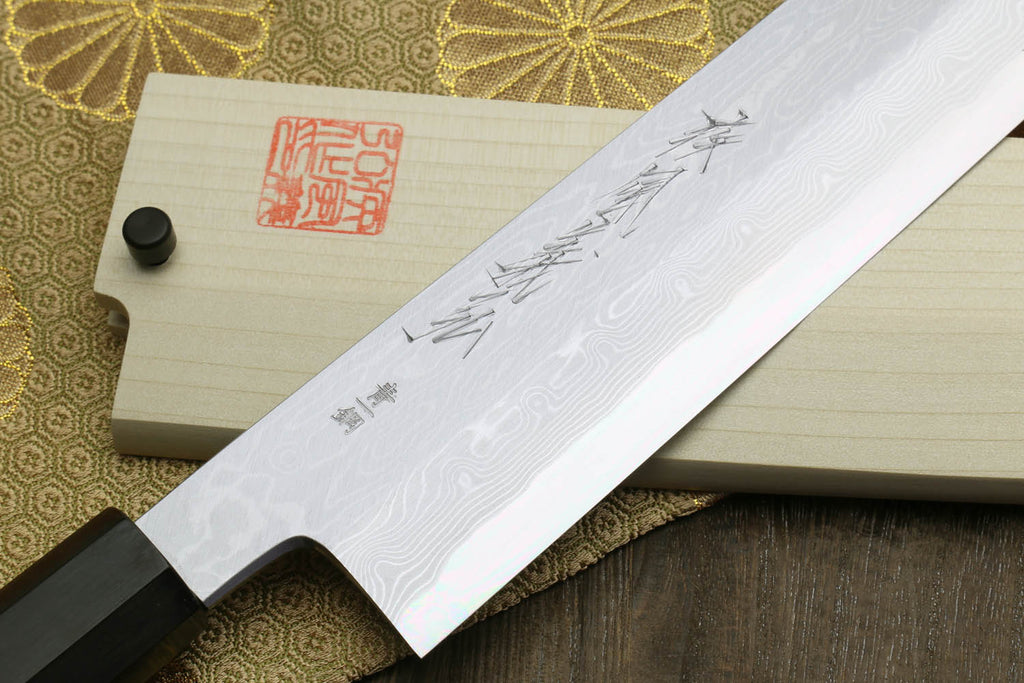 Japanese chef knife blade with pale finish and etched pattern, ebony handle