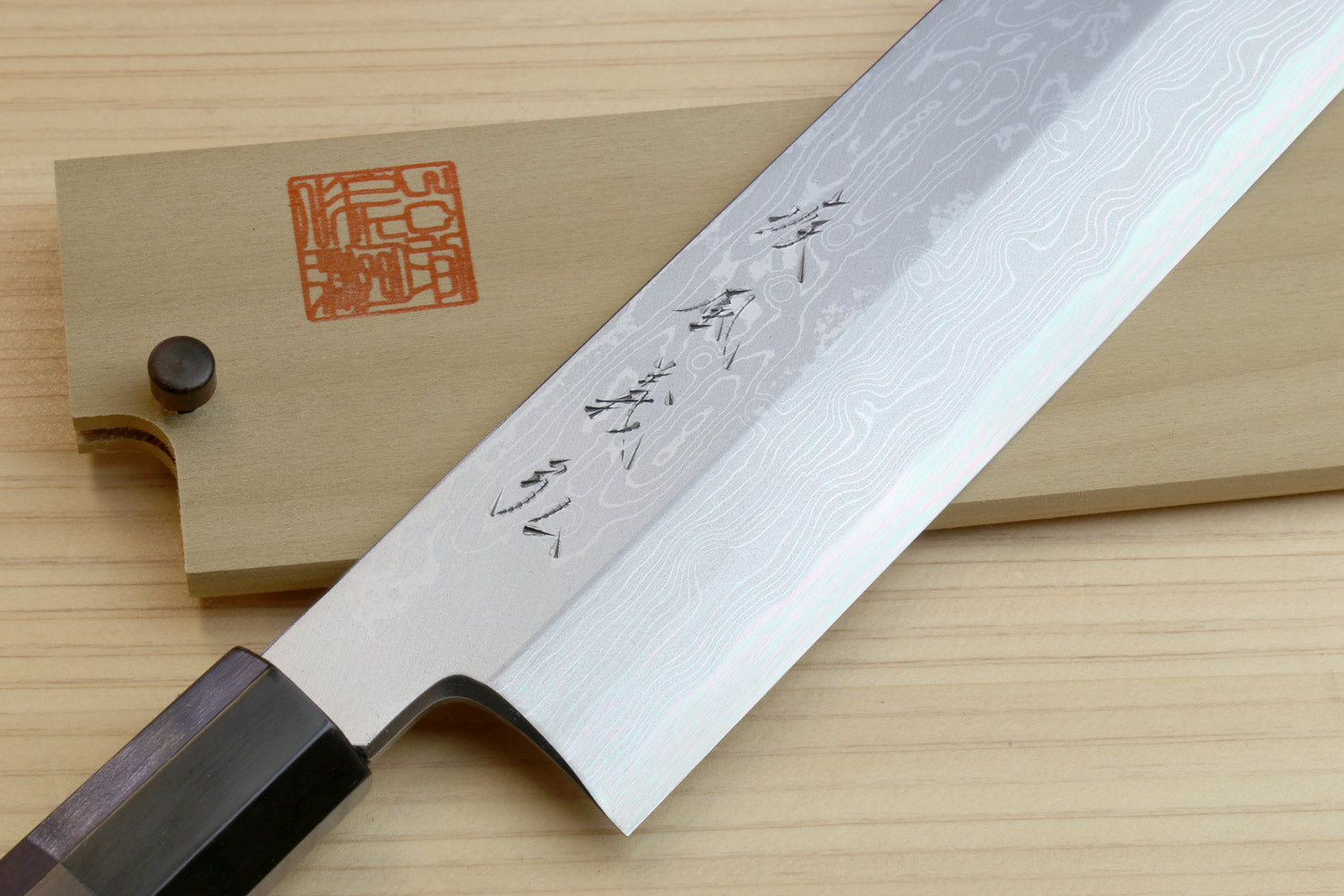 Japanese vegetable prep knife with damascus-style blue pattern blade and ebony handle