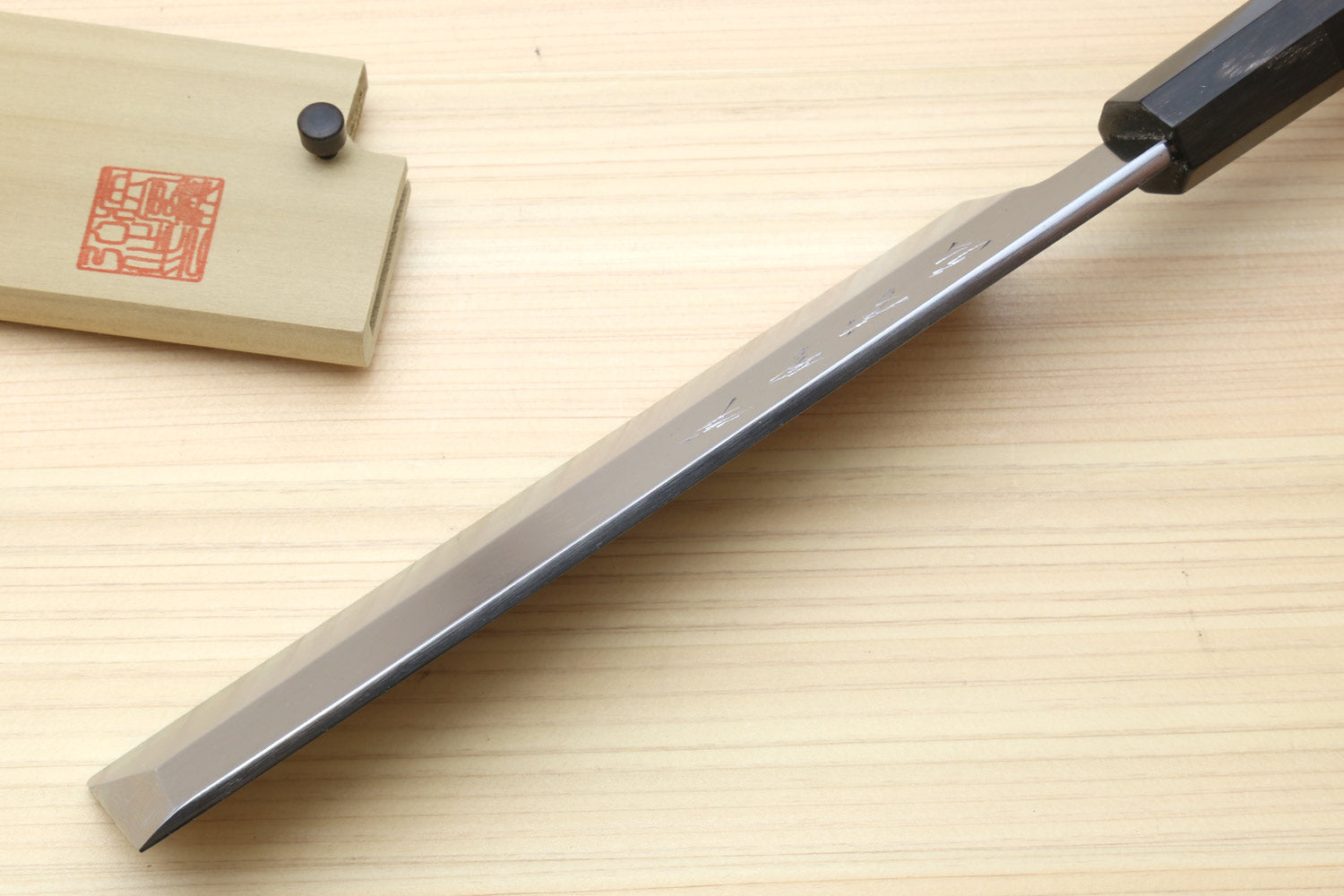 Japanese vegetable prep knife with long pointed damascus blade and dark wooden handle