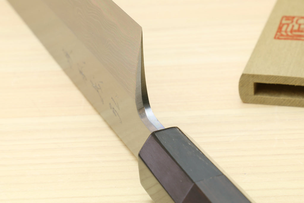 Japanese vegetable prep knife: close-up of curved blade edge and ebony handle
