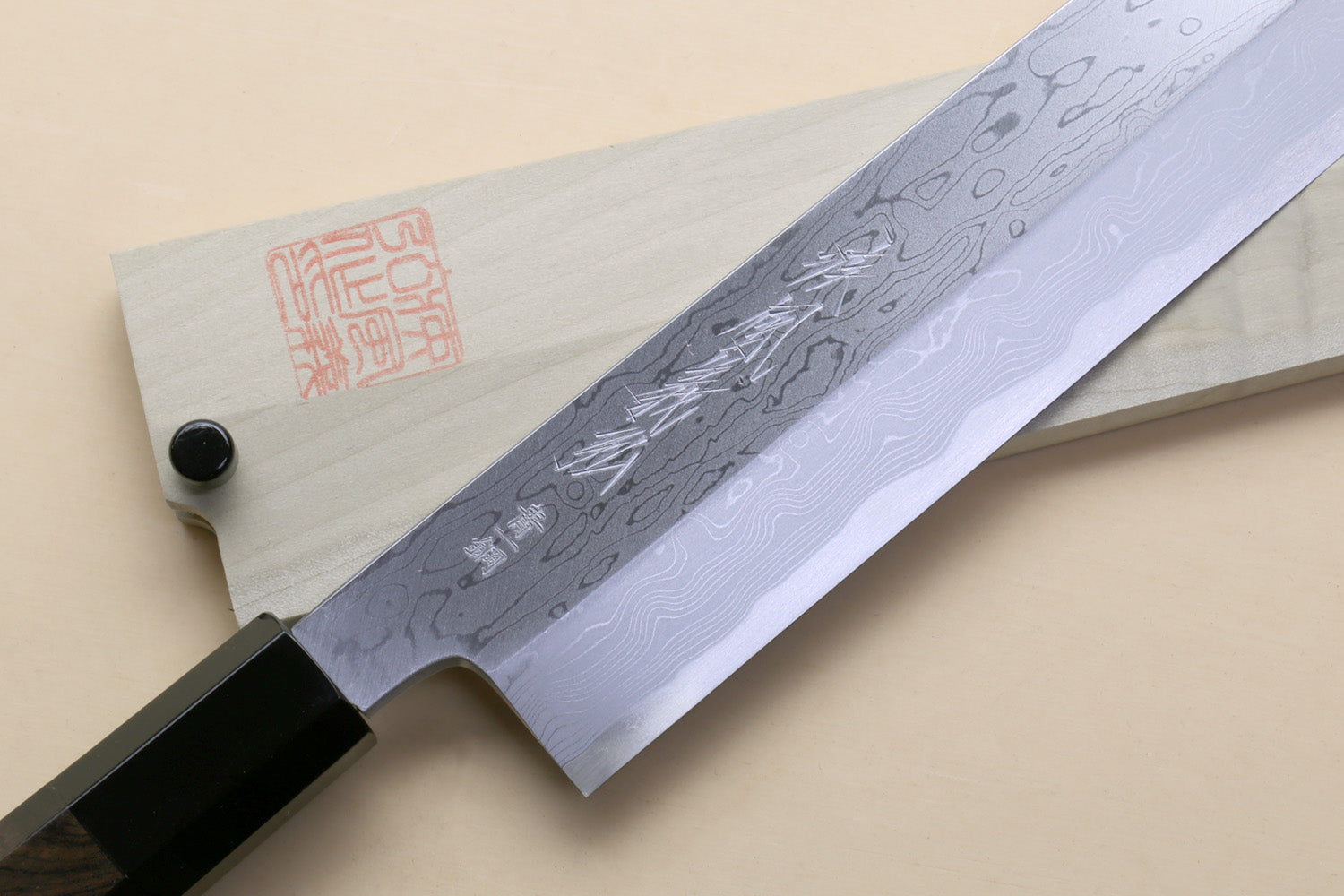 Japanese vegetable knife with patterned blue blade and black handle, shown in profile