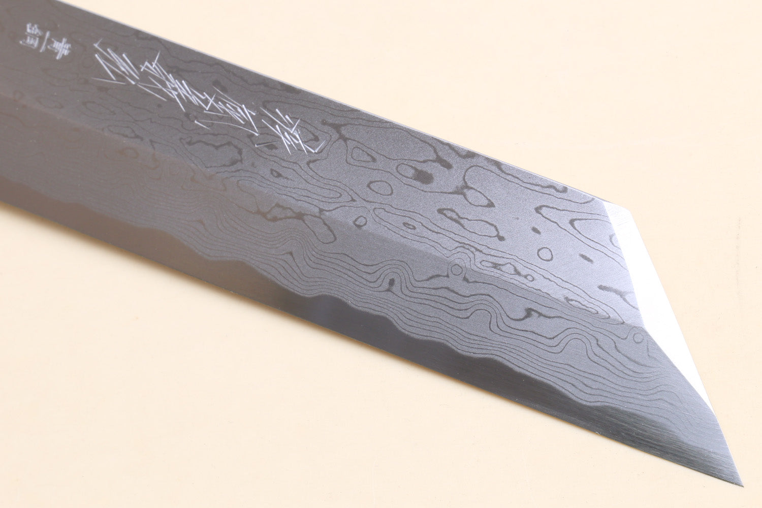 Japanese vegetable knife close-up of blue-steel blade with flowing damascus lines