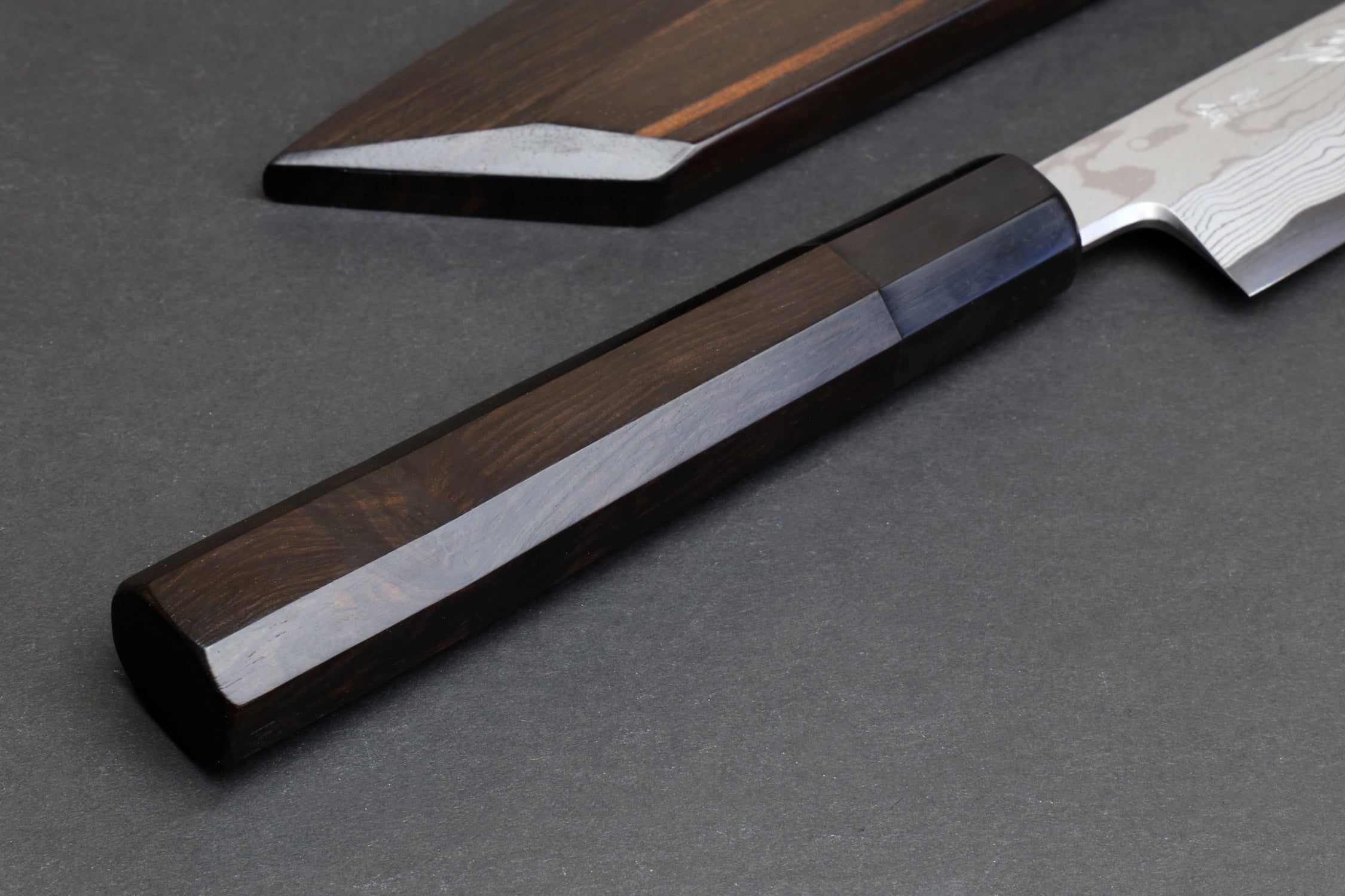 Japanese yanagi sushi knife with dark wood handle and damascus steel blade