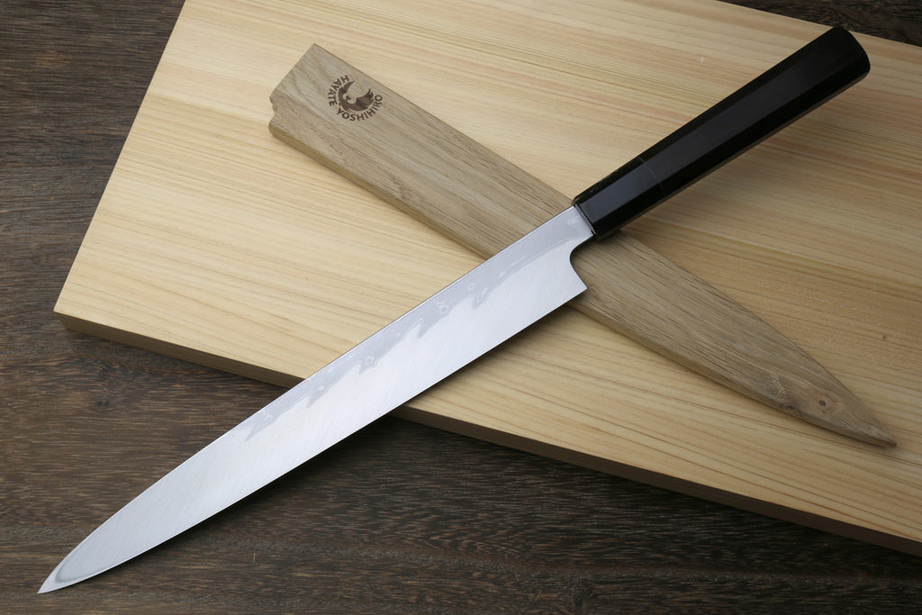 Yanagi sushi knife with black handle and long slender wavy steel blade